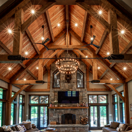 interior of timber framed home with lights turned on with living room furniture set up on the floor
