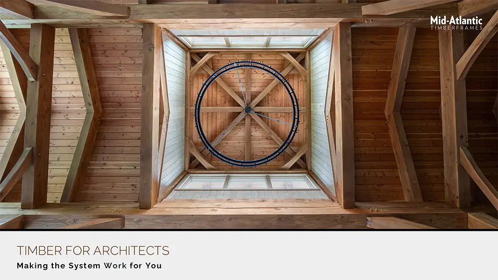 View looking up at a wooden timber-framed ceiling with a circular black metal chandelier in the center. Text reads: TIMBER FOR ARCHITECTS—Making the System Work for You, and Mid-Atlantic TimberFrames.